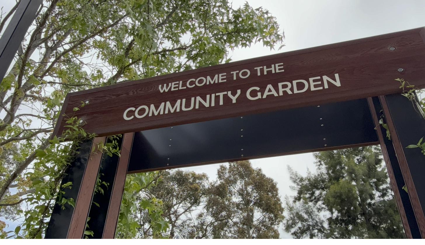Welcome to the Community Garden sign at the orchard entrance